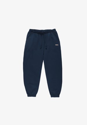 Granatowe spodnie dresowe z elastycznym pasem i ściągaczami, zapięcie na sznurek, kieszenie po bokach i małe logo "Prosto." na prawej udzie.