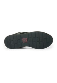 Black shoe sole with textured grip patterns and a red label in the center reading "Ara High Soft," size 4½ visible near the label.