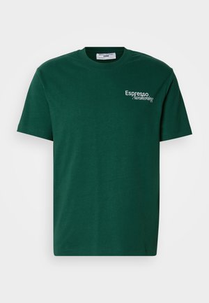 Ciemnozielona bawełniana koszulka z krótkim rękawem, okrągłym dekoltem i białym napisem "Espresso Awakening" na lewej piersi. Gładka struktura.