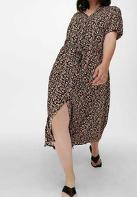 Floral-printed black dress with short sleeves, v-neck, side slit, and loose fit. Made of lightweight fabric, featuring pink and blue flower patterns.