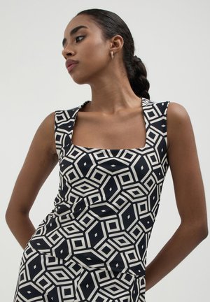 Top senza maniche a motivo bianco e nero con scollo quadrato, design geometrico, tessuto morbido e silhouette aderente.