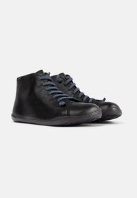 Botas de cuero negras hasta el tobillo con cordones azul marino, punta redonda, textura suave y un sutil detalle de costura, diseñadas para un uso cómodo.