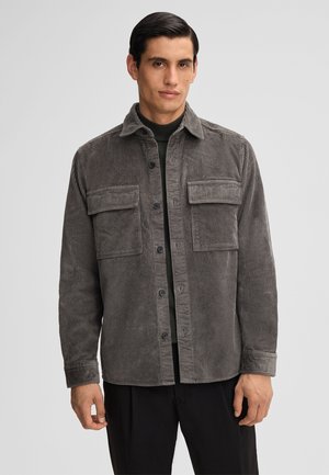 Grau gestreifte Baumwolljacke mit zwei Fronttaschen, Knopfverschluss und Kragen. Der strukturierte Stoff verleiht dem Design Tiefe. Lässige Passform.