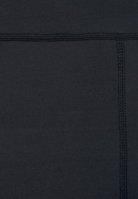 Schwarze enganliegende Leggings mit glatter Textur, verstärkten Nähten und minimalistischem Design, geeignet für verschiedene Aktivitäten.