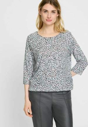 Lichtgewicht top in een subtiele dierenprint met een mix van blauwe, roze en zwarte kleuren. Heeft driekwartmouwen en een ronde hals.