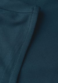 Tissu à rayures bleu canard foncé avec une texture lisse ; présente des coutures visibles le long du bord, mettant en valeur une finition nette et un détail de design.