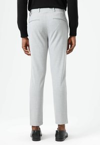 Lichtgrijze op maat gemaakte broek met een textuureffect, voorzien van een slanke pasvorm, riemlussen en twee achterzakken met subtiele biesaccenten.