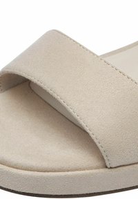 Beige slip-on szandálok, puha velúr felsőrésszel, széles pánttal és kerek talppal. A textúra simának tűnik, minimális varrási részletekkel.
