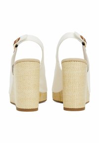 Sandalias de plataforma blancas con un tacón tejido en beige texturizado. Cuenta con una correa trasera con un hebilla en tono dorado y una parte superior suave y mate.