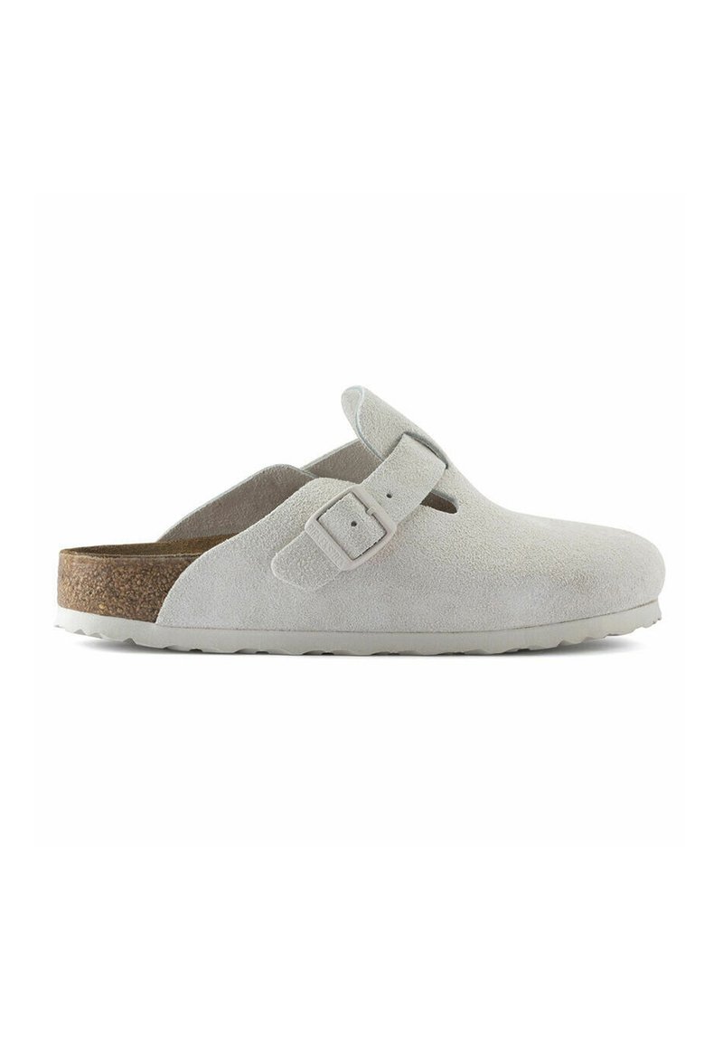 Zoccoli in suede grigio chiaro con fibbia regolabile, sottopiede in sughero e suola in gomma testurizzata, caratterizzati da una punta arrotondata e un design aperto sul retro.