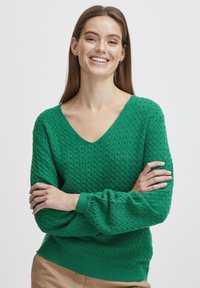 Grüner V-Ausschnitt-Pullover mit strukturiertem Muster, langen Ärmeln und gerippten Bündchen. Leichter Stoff; tailliert für einen sicheren Sitz.