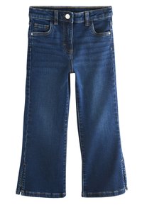 Tmavomodré riflové nohavice so rovno strihaným strihom, ktoré majú päť vreciek, viditeľné švy a bočné rozparky na leme.