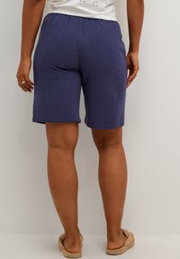 Marineblå shorts lavet af letvægtsstof med elastisk talje, afslappet pasform og lige snit, der falder over knæet.