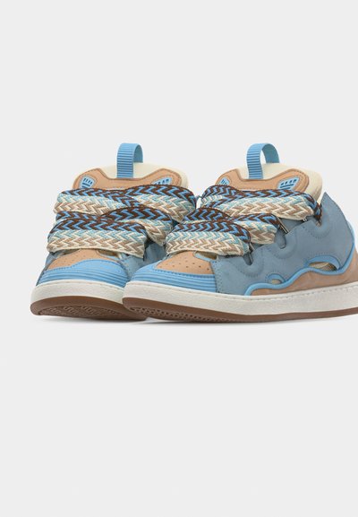 Baskets basses en bleu, beige et marron avec des lacets épais à motifs et des languettes de traction, vue avant en angle sur fond blanc.
