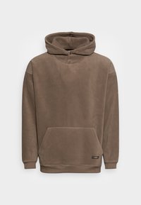 Hættebluse i brun, lavet af blødt fleece stof. Har en kengurulomme samt ribbede manchetter og kant. Simpelt, minimalistisk design.