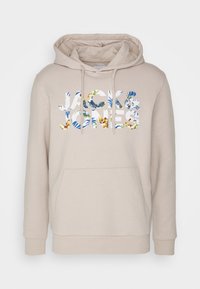 Béžová mikina s klokankou, kapucňou na šnúrku a logom "JACK & JONES" s kvetinovými vzormi v modrej, zelenej a žltej farbe.