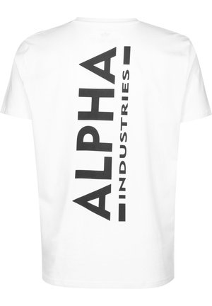 T-shirt en coton blanc avec une grande impression verticale noire du mot "ALPHA" et "INDUSTRIES." Manches courtes et design col rond.
