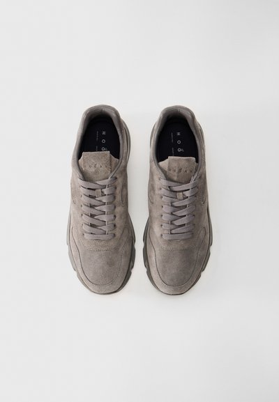 Pair of gray suede sneakers with laces, viewed from above on a plain white background, brand name on the tongue.