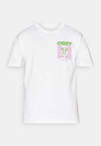 Balta medvilninė marškinėliai su žalia ir rožine grafika priekyje, įskaitant tekstą "OBEY" ir stilizuotą veidą rėmelyje.