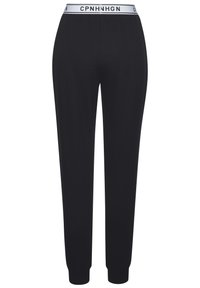 Mustat joogahousut, jotka on valmistettu pehmeästä kankaasta, joissa on valkoinen joustava vyötärö, johon on merkitty teksti "CPNHNHGN". Kapeneva lahjakuvio cuffeilla.