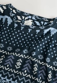 Sötétkék pamut póló, világoskék és fehér geometriai mintákkal, kerek nyakkivágással és "NEXT time" feliratú címkével.