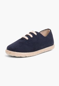Scarpa stringata in suede blu navy con punta rotonda e suola in juta intrecciata beige, caratterizzata da tre occhielli beige e un design minimale.