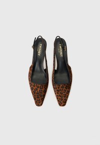 Brune leopardmønster slingback-sko med spiss tå, svart innfôring og justerbar ankelrem. Glatt tekstur med et unikt mønster.
