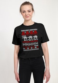 Czarna koszulka z festiwalowym wzorem w odcieniach czerwieni, szarości i bieli, z grafikami w tematyce Gwiezdnych Wojen, w tym z żołnierzami szturmowymi i AT-AT.