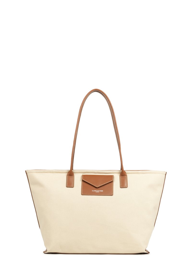 Borsa tote in canvas color avorio con accenti in pelle marrone. Presenta due manici lunghi e una tasca anteriore. Dettagli cuciti lungo i bordi.