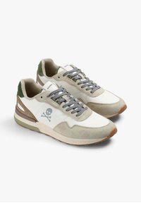 Heren sneakers met een beige en witte leren bovenmaterialen, grijze veters, groene suède accenten en een schedelafbeelding aan de zijkant. Rubberen zool.