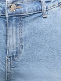 Povečava svetlo modrih kavbojk iz jeansa, ki prikazuje sprednji žep, zanko za pas in srebrni gumb z všitimi detajli.