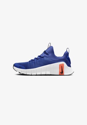 Baskets de sport bleues avec semelle blanche, logos Nike noirs sur l’orteil et le talon, et accent orange près du talon, lacées et vues de côté.