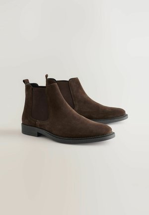 Bocanci de glezna din suede maro, cu panouri laterale elastice, vârfuri rotunjite și un toc jos. Prezintă un design minimalist, cu un finisaj texturat.