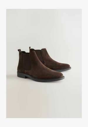 Braune Wildleder-Ankle-Boots mit elastischen Seitenpaneelen, abgerundeten Zehen und einem niedrigen Absatz. Sie besitzen ein minimalistisches Design mit einer strukturierten Oberfläche.