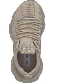 Baskets en tricot beige avec semelle épaisse, fermeture à lacets à l'avant, ornements en cristal sur le côté, et étiquette "Steve Madden" sur la languette et la semelle intérieure.