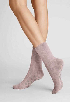 Rosa, gerippte Knöchelsocken mit einem gerafften Bund und grünen Sternmustern auf den Sohlen, aus einem weichen Stoff gefertigt.