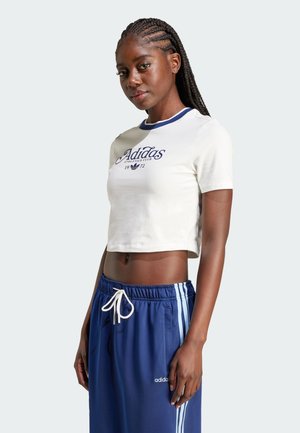 T-shirt bianca corta con bordino blu, caratterizzata dal logo "Adidas Athletics Club" in blu navy. Abbinata a pantaloni navy con strisce bianche.