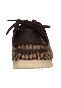 Kengät, joissa on ruskea nahka ja ruudullinen kangas, nauhakiinnitys, franssit ja vaaleankerman värinen kumipohja. Näkymä edestä.