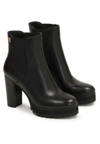 Mustad nahast pahkluu saabid paksude kõrgete kontsade, elastsete küljeplokkide, tekstureeritud tallade ja väikese kuldse logoga välimisel äärel.