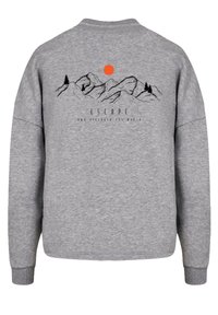 Grijze sweatshirt met lange mouwen, voorzien van een bergafbeelding, een oranje zon en de tekst "ESCAPE" afgedrukt op de rug.