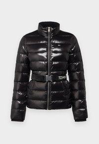 Svart vadderad jacka med glansig yta, hög krage, dragkedja framtill och ett skärp med "TOMMY"-logotyp. Isolerad och kviltad design.