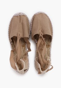 Espadrillas in tela beige con suole in juta intrecciata, cuciture bianche e lacci in nastro. Texture liscia con design della punta arrotondata.