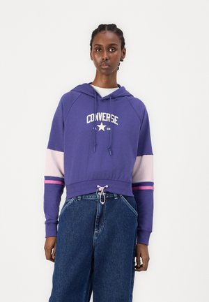 Purple cropped hoodie with white "Converse" logo, featuring pink and light purple accents on sleeves and a drawstring at the hem.