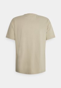 Beige short-sleeve t-shirt shown from the back with a round neck and a small stitched triangle detail below the collar.