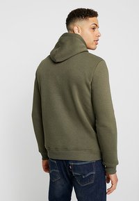 Olivengroene katoenen hoodie met een aansluitende kap, ribgebreide manchetten en tailleband. Glad textuur en een eenvoudig ontwerp zonder zichtbare patronen.