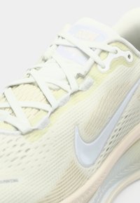 Ανοιχτό πράσινο αθλητικό παπούτσι με υφασμάτινη επάνω επιφάνεια, λευκά κορδόνια και αντανακλαστικό λογότυπο Nike. Διαθέτει μαλακή σόλα για άνεση.