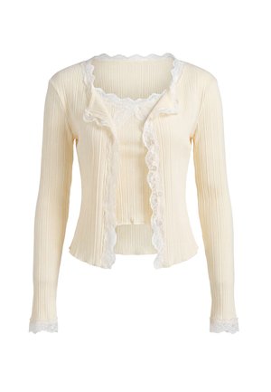 Cardigan crema a coste con maniche lunghe e top abbinato, con rifiniture in pizzo su bordi e polsini, mostrato su sfondo bianco.