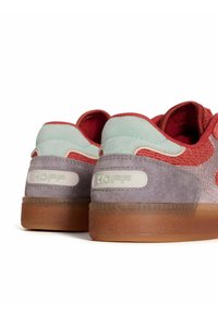 Baskets avec un dessus en daim violet, des accents en textile rouge et des détails au talon verts. Présente une semelle en caoutchouc texturé et un logo au talon.