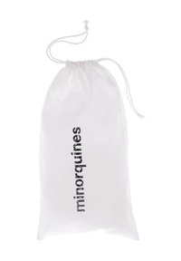 Sac à cordon blanc en tissu, avec le mot « minorquines » imprimé verticalement en noir. Texture douce, design léger.