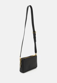 Sac en cuir noir texturé à bandoulière réglable, matériel doré et compartiment principal zippé.